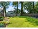 A large, grassy backyard with lush greenery, mature trees, and landscaped areas at 504 Angier Ne Ave, Atlanta, GA 30308