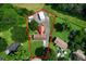 Aerial view of a home with a red roof, outbuildings, and a large yard surrounded by mature trees at 81 Laurie Ct, Hiram, GA 30141