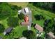 Aerial view of a home with a red roof, outbuildings, and a large yard surrounded by mature trees at 81 Laurie Ct, Hiram, GA 30141