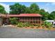 Charming exterior view of screened-in porch with red roof, set amidst lush landscaping at 81 Laurie Ct, Hiram, GA 30141
