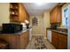 Galley kitchen featuring granite countertops, wood cabinets, and tile flooring at 81 Laurie Ct, Hiram, GA 30141