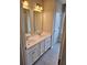 Bathroom with white cabinets, dual vanity, tiled floor and framed mirror at 105 Marchmont Dr, Locust Grove, GA 30248