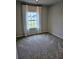 This bedroom features carpeting and a window with light filtering curtains, offering a cozy atmosphere at 105 Marchmont Dr, Locust Grove, GA 30248
