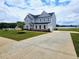 Long concrete driveway leading to a gray two-story home with a manicured lawn at 105 Marchmont Dr, Locust Grove, GA 30248