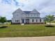 Charming two-story home with gray siding, a blue front door, and a well-manicured lawn at 105 Marchmont Dr, Locust Grove, GA 30248