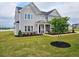 Well-maintained front yard with a gray home, fresh landscaping, and green grass at 105 Marchmont Dr, Locust Grove, GA 30248