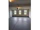 A spacious garage with a sealed concrete floor and three large windows at 105 Marchmont Dr, Locust Grove, GA 30248