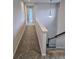 The carpeted hallway overlooks a staircase and is illuminated by a modern pendant light at 105 Marchmont Dr, Locust Grove, GA 30248