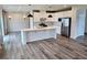 Open-concept kitchen with stainless steel appliances, white cabinetry, large island, and hardwood floors at 105 Marchmont Dr, Locust Grove, GA 30248