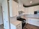 Close-up of a modern kitchen showcasing white cabinets, stainless steel appliances, and a gas range at 105 Marchmont Dr, Locust Grove, GA 30248
