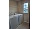 The laundry room features modern appliances and a window that provides natural light at 105 Marchmont Dr, Locust Grove, GA 30248
