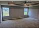 The main bedroom features tray ceilings, two windows, and carpet floors at 105 Marchmont Dr, Locust Grove, GA 30248