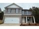 Two-story home features a two-car garage, a covered porch, and a yard surrounded by mature trees at 123 Deer Xing, Temple, GA 30179