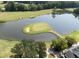 Scenic aerial view of a challenging golf green surrounded by a lake and mature trees at 14 Augusta Way, Hiram, GA 30141