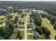 Aerial view of a neighborhood with a mix of homes, green spaces, and a small lake in the background at 14 Augusta Way, Hiram, GA 30141