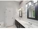 Bathroom with dual sinks, vanity, large framed mirror, tub, and lighting fixtures at 14 Augusta Way, Hiram, GA 30141