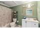 Bathroom with white vanity, decorative shelving unit, and shower with seashell shower curtain at 14 Augusta Way, Hiram, GA 30141