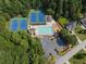 Bird's eye view of community amenities including tennis courts, a pool, and parking area amid trees at 14 Augusta Way, Hiram, GA 30141