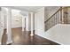 Entryway featuring hardwood floors, columns, an iron-spindled staircase, and paneled dining room at 14 Augusta Way, Hiram, GA 30141