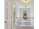 Bright hallway features decorative chandelier and railing with natural light and neutral paint color at 14 Augusta Way, Hiram, GA 30141