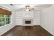 Cozy living room with a fireplace, built-in bookshelves, hardwood flooring, and a ceiling fan at 14 Augusta Way, Hiram, GA 30141