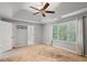 Large main bedroom with tray ceiling, fan, and light filled window features a bathroom doorway at 14 Augusta Way, Hiram, GA 30141