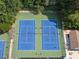 Aerial view of multiple tennis courts surrounded by lush trees and greenery at 14 Augusta Way, Hiram, GA 30141
