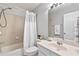 Well-lit bathroom featuring a shower-tub combo and a large vanity mirror at 110 Finchley Dr, Roswell, GA 30076