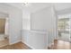 Bright upstairs hallway with hardwood flooring leading to a bathroom and bedroom at 110 Finchley Dr, Roswell, GA 30076