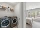 Modern laundry area with washer, dryer, and shelving, next to bedroom at 110 Finchley Dr, Roswell, GA 30076