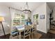 Sunlit dining room with a large window, stylish chandelier, and views of the outdoors at 2751 Pilgrim Mill Rd, Cumming, GA 30041