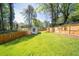 A well-maintained backyard featuring a large grassy area and a charming shed with a fence at 308 Reed St, Scottdale, GA 30079