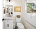 Elegant powder room featuring a marble countertop vanity, black hardware, and stylish mirror at 308 Reed St, Scottdale, GA 30079