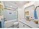 Stylish bathroom featuring marble counters, updated fixtures, shower-tub combo and contemporary mirrors at 308 Reed St, Scottdale, GA 30079