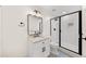 Stylish bathroom featuring white vanity, a modern sink, a walk-in shower with black-framed glass, and neutral tile at 308 Reed St, Scottdale, GA 30079