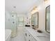 Modern bathroom showcasing a glass-enclosed shower, soaking tub, and dual marble countertop sinks at 308 Reed St, Scottdale, GA 30079