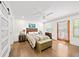 Bright bedroom featuring wood floors, ceiling fan, wood accent headboard, and access to the backyard at 308 Reed St, Scottdale, GA 30079
