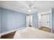 Airy bedroom with soft blue walls, hardwood floors, a ceiling fan, and multiple closets at 308 Reed St, Scottdale, GA 30079