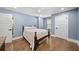Comfortable bedroom with hardwood floors, blue walls, and two entry doors at 308 Reed St, Scottdale, GA 30079