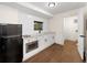 Clean, modern kitchenette with white cabinets, sleek black appliances, and hardwood floors at 308 Reed St, Scottdale, GA 30079