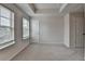 Bedroom with neutral carpet and walls, tray ceiling, natural light from windows, and two doors at 3587 Hidden Valley Cir, Lawrenceville, GA 30044