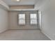 Bright bedroom with carpeted floors, a tray ceiling, and large windows for natural light at 3587 Hidden Valley Cir, Lawrenceville, GA 30044