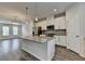 Modern kitchen features white cabinets, granite countertops, stainless steel appliances, and wood flooring at 3587 Hidden Valley Cir, Lawrenceville, GA 30044