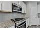 Modern kitchen features stainless steel oven and microwave, plus granite countertops and white cabinets at 3587 Hidden Valley Cir, Lawrenceville, GA 30044