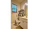 Cozy bathroom features a vanity with storage space, toilet, and decorative shelving unit at 5783 Poppy Tree Ln, Tucker, GA 30084
