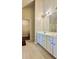 Bathroom featuring tile floors, ample storage, double vanity, and access to large closet at 5783 Poppy Tree Ln, Tucker, GA 30084