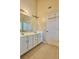 Bathroom featuring tile floors, ample storage, double vanity, and large framed mirror at 5783 Poppy Tree Ln, Tucker, GA 30084