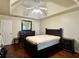 Spacious bedroom with hardwood floors, tray ceiling, and dark wood furniture at 5783 Poppy Tree Ln, Tucker, GA 30084