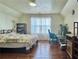 Bedroom featuring hardwood floors, natural light from large window, and space for desk and computer at 5783 Poppy Tree Ln, Tucker, GA 30084