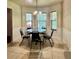 Bright breakfast nook features a round table, chandelier, and three windows overlooking the backyard at 5783 Poppy Tree Ln, Tucker, GA 30084